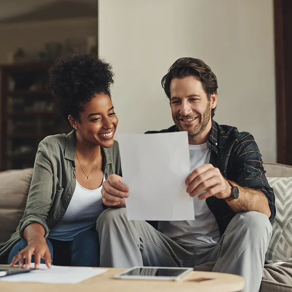 Happy couple reviewing financial documents after obtaining alternative financing