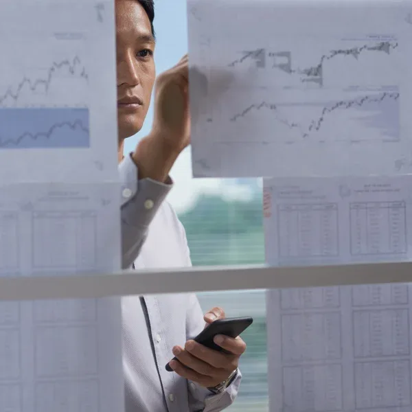 A man examines graphs on a screen, carefully analyzing data.