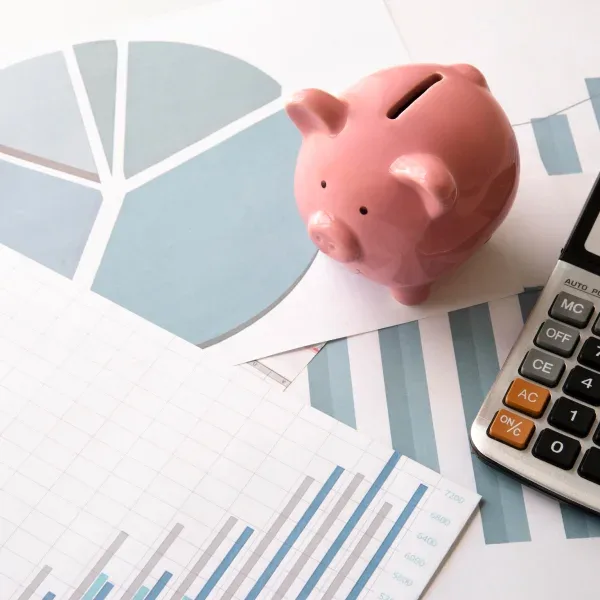 A piggy bank, calculator, and financial documents on a desk, symbolizing a fast $1500 loan process.