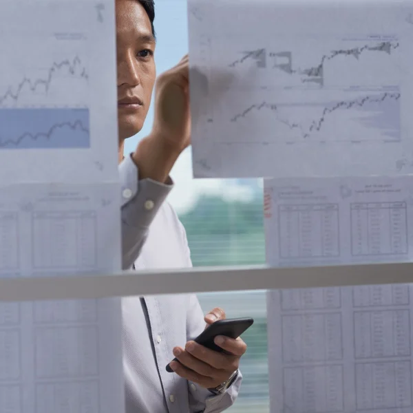 A man examines graphs on a screen, carefully analyzing data.