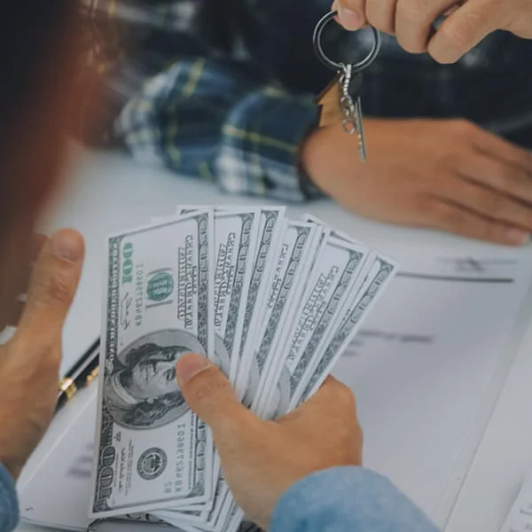 Un homme remet de l'argent à une autre personne dans un échange financier.